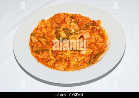 Traditional Greek spicy food with pork pieces in hot spicy red sauce Stock Photo