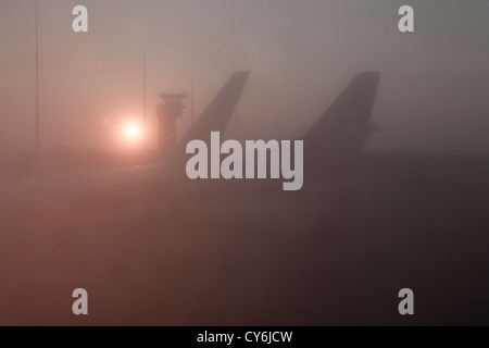 Sunrise and foggy sky through a plane window in the early morning. Stock Photo