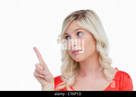 Young woman pointing something in the air with her finger Stock Photo