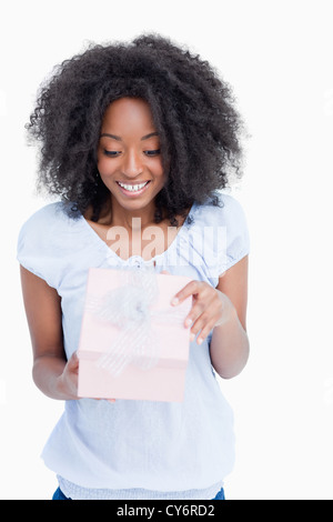 Happy young woman opening her birthday gift Stock Photo