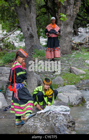 Kalash girls washing clothes in the stream running through the village of Balanguru, Rumbur Valley, Chitral, Khyber-Pakhtunkhwa, Pakistan Stock Photo