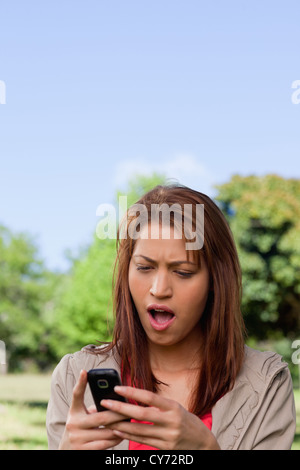 Woman with a shocked while reading a text message Stock Photo