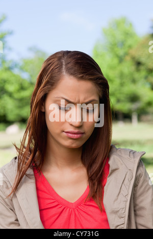 Woman looking downwards with a disappointed expresssion on her face Stock Photo