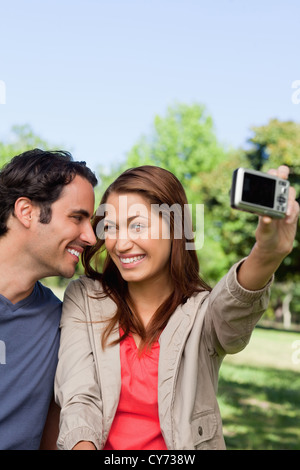 Young woman and her friend look at each other while she takes a photo Stock Photo