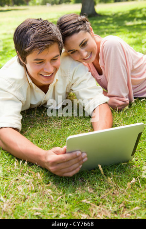 Woman leans against her friend as they use a tablet together Stock Photo