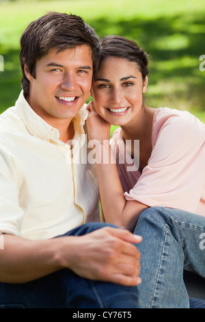 Woman leaning on her friend's shoulder while sitting with him Stock Photo