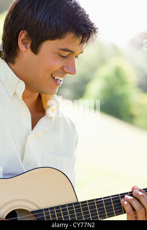 Man smiling as he plays a guitar Stock Photo