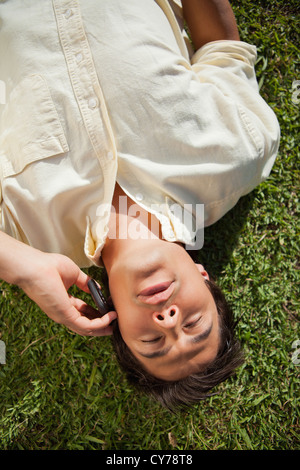 Man talks on the phone while lying on the grass Stock Photo