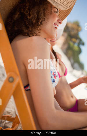 Side view of young attractive women sitting on deck chairs Stock Photo