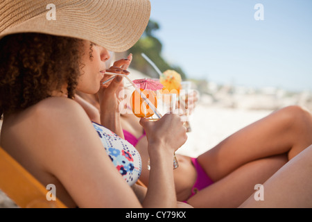 Side view of a beautiful woman sipping her cocktail accompanied by her friend Stock Photo
