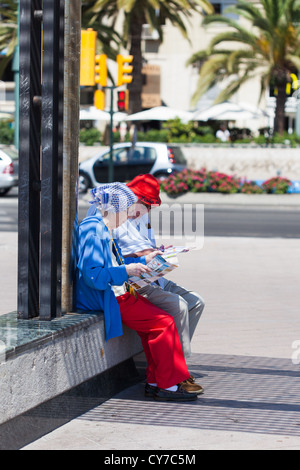 mature couple .Tourists consulting guidebook  Malaga. Spain. Old couple looking at map. Malaga. Stock Photo