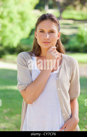Thoughtful woman standing in the park Stock Photo
