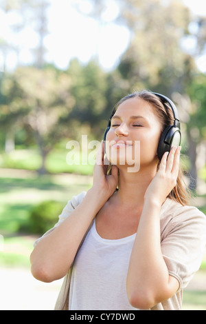 Woman with headphones enjoying music in the park Stock Photo