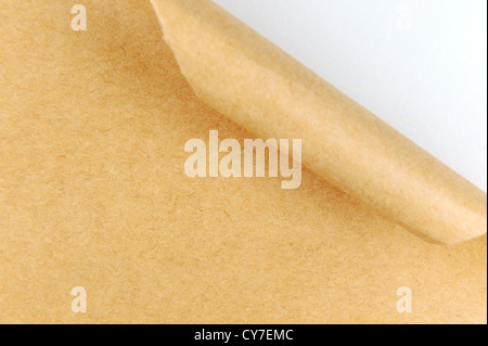 Curled yellow paper revealing white paper behind it Stock Photo