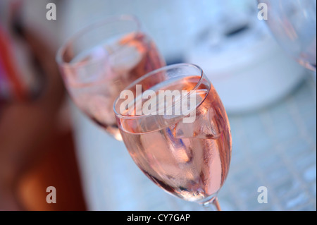 2 glasses full of light pink-rose coloured wine with ice cubes,with one out of focus Stock Photo