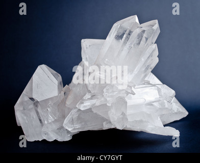 Large crystals of white quartz on dark blue background Stock Photo