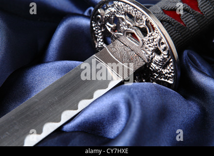 close-up of Japanese katana sword on blue satin background Stock Photo