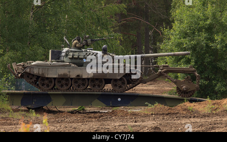 T-55M main battle tank of the Finnish Army with KMT-5 mine clearing roller crossing bridge. Stock Photo