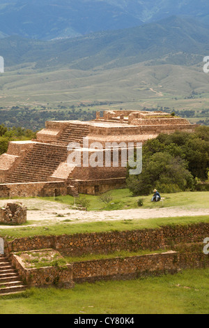 Hispanic man sits near pyramid at Monte Alban archaeological site, Oaxaca, Mexico Stock Photo