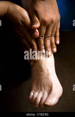 The foot of an old woman being massaged / feet massage on a senior / oap / older woman / person. Stock Photo