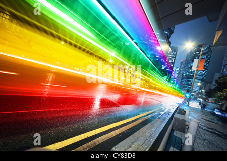 Long exposure shot of blurred bus speeding through night street. Stock Photo