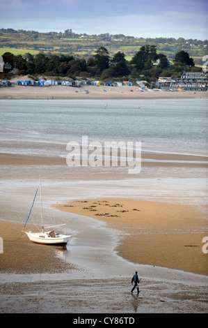 A fisherman carrying a spade to dig for lugworms crosses the sands on Borth Fawr or Main Beach at Abersoch on the Lleyn Peninsul Stock Photo