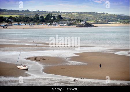 A fisherman carrying a spade to dig for lugworms crosses the sands on Borth Fawr or Main Beach at Abersoch on the Lleyn Peninsul Stock Photo