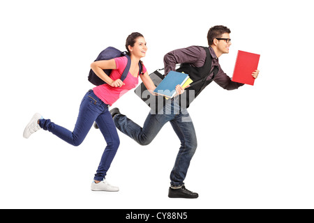 Male and female students rushing forwards with books in their hands, focus on the boy Stock Photo