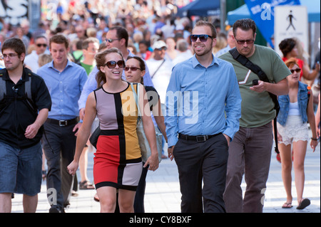 Smiling couple walking amongst  the crowd in Montreal, province of Quebec, Canada. Stock Photo