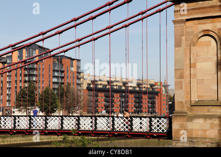 Looking through South Portland Street Suspension Bridge to modern apartments on Clyde Street in Glasgow city centre, Scotland, UK Stock Photo