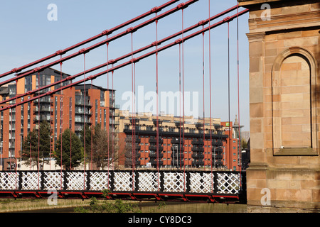 Looking through South Portland Street Suspension Bridge to modern apartments on Clyde Street in Glasgow city centre, Scotland, UK Stock Photo