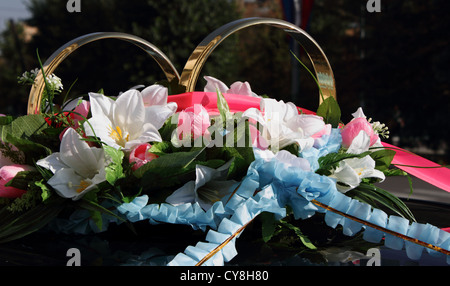 wedding limousine decorated with flowers and gold rings Stock Photo