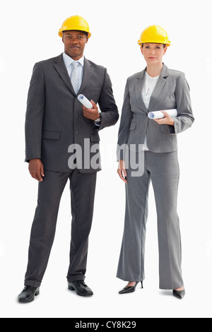 Two serious business people wearing hard hats Stock Photo