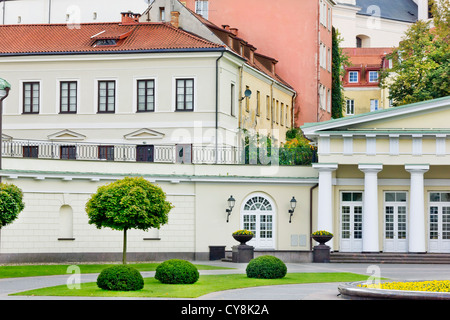 A fragment of a plain public domain old European city. Red tiled roofs, columns, windows and flowers. Stock Photo