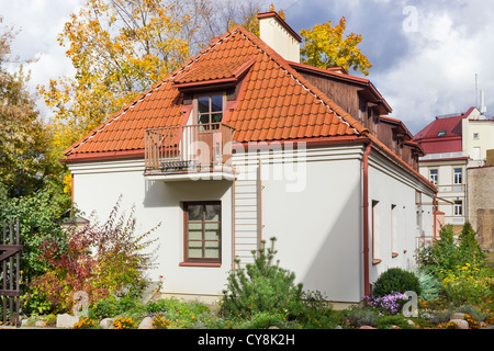 A fragment of a plain public domain mass old European city. Red tiled roofs, walls, windows and flowers. Stock Photo
