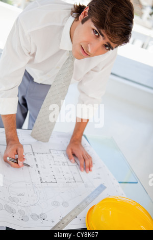 Businessman looks upwards worried as he works Stock Photo