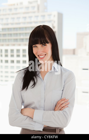 Woman with her arms crossed over and smiling Stock Photo