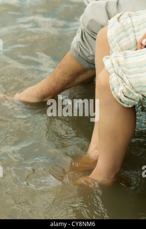 Couple soaking feet in water, cropped Stock Photo