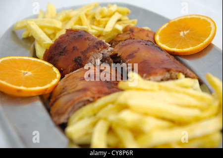 Leitão assado - traditional Portugal Bairrada region roasted piglet with french fries and orange Stock Photo