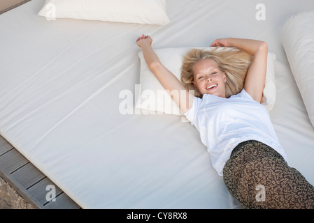 Young woman relaxing on bed Stock Photo