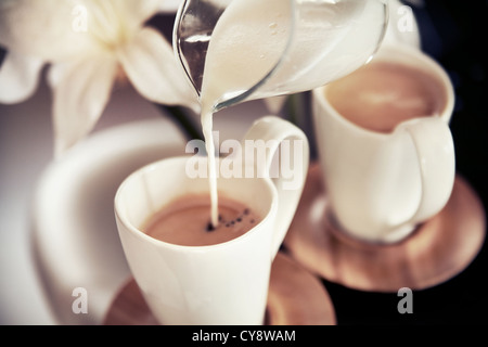 Two cups of coffee with decoration and poured milk