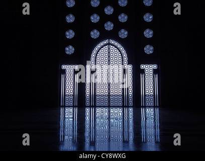 Blue light reflects off marble floor from illuminated stained glass windows framing doorway into mosque in Casablanca Stock Photo