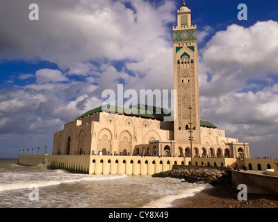 View of Hassan II Mosque and Minaret in Casablanca, Morocco with waves crashing against its sea walls Stock Photo