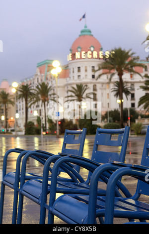 The blue chairs and the Negresco palace hotel in the Promenade des Anglais in Nice Stock Photo