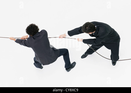 Businessmen playing tug-of-war Stock Photo