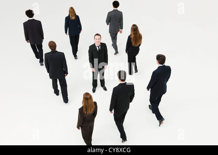 Businessman standing in midst of other anonymously dressed business professionals Stock Photo