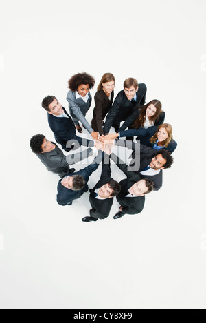 Business associates standing in circle with hands clasped in motivational exercise Stock Photo