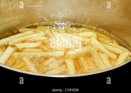 French fries frying in hot oil with space for text Stock Photo