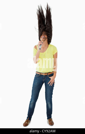 Young woman singing while shaking her head Stock Photo