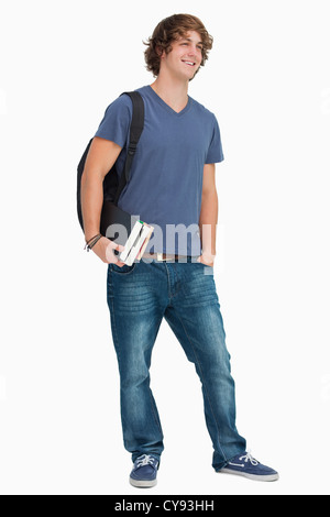 Male student with backpack and books standing and showing a smartphone ...